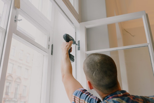 man reparing door frame in house